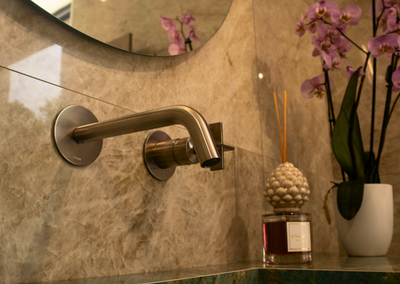 Showroom arredo bagno e soluzioni per interni con rubinetto argentato incastonato nel muro - Lucio Melluso Messina